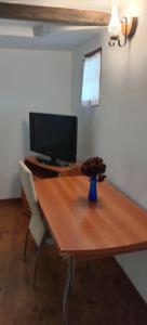 a wooden table with a television on top of it at Casa cu Turn in Sărata-Monteoru