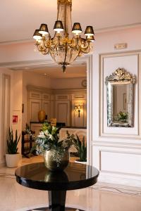 a room with a table and a chandelier at Thermae Sylla Spa & Wellness Hotel in Loutra Edipsou