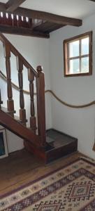 a stairwell with a wooden stair railing in a room at Casa cu Turn in Sărata-Monteoru