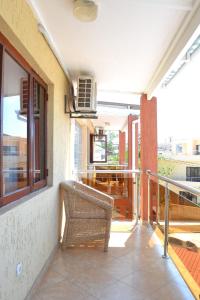 a balcony with a wicker chair sitting on a porch at Kutenga Guest House in Maputo