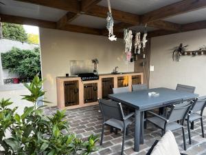 a patio with a table and chairs and a kitchen at Gite la pause corrézienne in Troche +12 photos