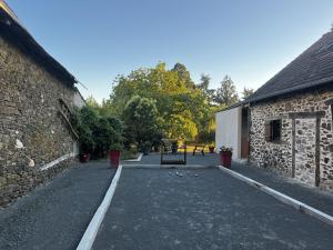 an empty driveway in front of a stone building at Gite la pause corrézienne in Troche