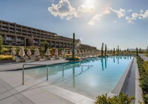 a swimming pool with umbrellas and a resort at Akra Didim Resort & SPA in Didim