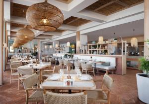 a restaurant with tables and chairs and a bar at Akra Didim Resort & SPA in Didim