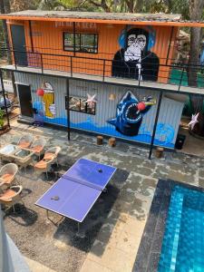 a house with a purple ping pong table next to a pool at Half Orange in Vagator