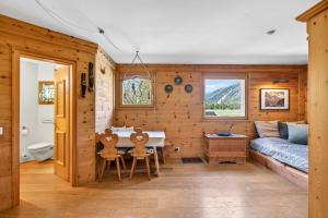 a living room with a couch and a table and chairs at Alpine Studio Flat near Sankt Moritz in Celerina +18 photos