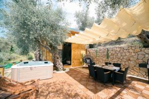 an outdoor patio with a hot tub and a table and chairs at Eden's Garden Villa in Ulcinj