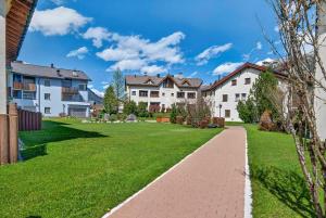 a house with a green lawn and a brick walkway at Alpine Studio Flat near Sankt Moritz in Celerina