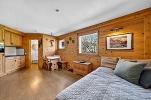 a bedroom with a bed and a desk and a kitchen at Alpine Studio Flat near Sankt Moritz in Celerina