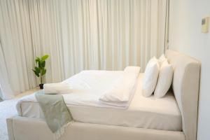 a white bed with white pillows on it in a room at Al Dana H2O Beachfront Villa with a private pool, Al Dana Island Sharm Fujairah in Sharm +51 photos