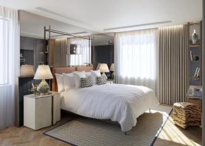 a bedroom with a large bed with white sheets and pillows at The St. Regis London in London