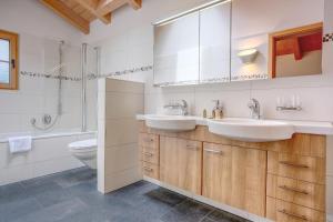 a bathroom with two sinks and a toilet at Apartment Bränderli - GRIWA RENT AG in Grindelwald +21 photos