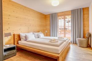 a bedroom with a large bed with a wooden wall at Apartment Bränderli - GRIWA RENT AG in Grindelwald