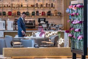 a man standing at a counter with a woman sitting at a table at Narcissus The Royal Hotel in Riyadh +131 photos