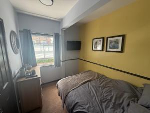 a bedroom with yellow walls and a bed and a window at The Fox Inn in Steventon