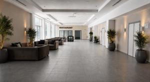 eine Lobby mit Sofas und Pflanzen in einem Gebäude in der Unterkunft Unipark Hotel in Kurna