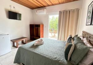a bedroom with a large bed and a television at Pousada Oceano Atlântico in Barra Grande