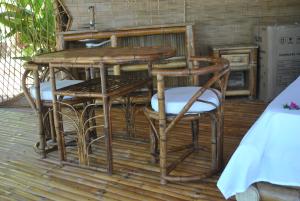 a wooden table and chairs on a deck at Le Caveau de lemuriens in Nosy Be