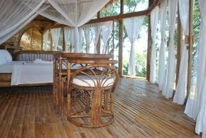 a bedroom with a table and a bed in a tent at Le Caveau de lemuriens in Nosy Be +6 photos