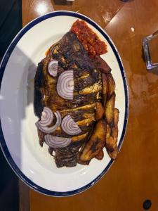 a white plate with a piece of meat and french fries at Cottingley Spring farm house in Leeds