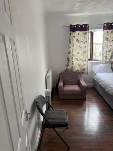 a bedroom with a chair and a bed and a window at Cottingley Spring farm house in Leeds