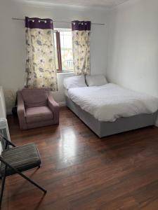 a small bedroom with a bed and a chair at Cottingley Spring farm house in Leeds