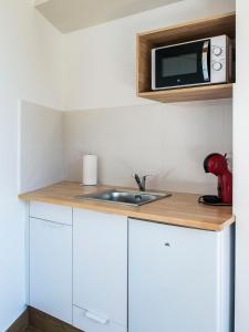 a kitchen with a sink and a microwave at A Calexa Sarria nº3 in Sarria