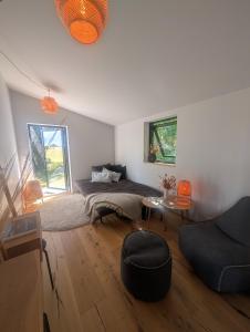 a bedroom with a bed and a table and a couch at Nordic Designer Summerhouse - With a fantastic view in Vejby