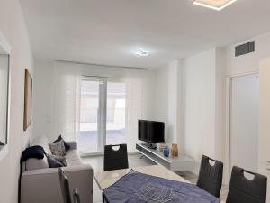 a white living room with a couch and a tv at golf time apartment - Lido di Venezia in Venice