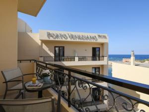 a balcony with a table and chairs and the ocean at Porto Veneziano Hotel in Chania
