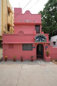 a pink building with plants in front of it at KHS Ranganath-G in Tiruchirappalli +2 photos