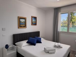 a bedroom with a bed with blue pillows and a window at golf time apartment - Lido di Venezia in Venice