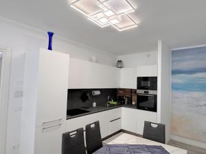 a white kitchen with a table and chairs at golf time apartment - Lido di Venezia in Venice