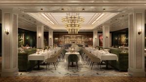 a restaurant with white tables and chairs and a chandelier at The St. Regis London in London