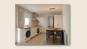 a kitchen with a table and a washing machine at Sweet Hill Bilbao in Bilbao