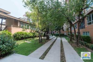 a sidewalk in front of a building with trees at Baan Thew Lom by D-light in Cha Am