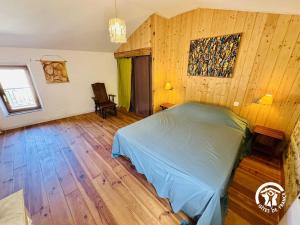 a bedroom with a bed and a wooden floor at Gîte de la jument rousse in Lagrasse
