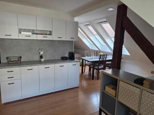 a kitchen with white cabinets and a dining room with a table at Michell Apartman Martin in Martin