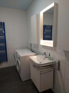 a bathroom with a washing machine and a sink at Lotsenwohnung B-9 in Butjadingen +16 photos