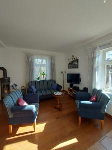 a living room with two blue couches and a television at Lotsenwohnung B-9 in Butjadingen