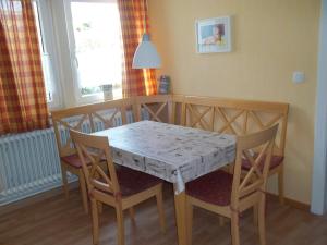 a dining room table with two chairs and a table and a table and chairsktop at Ankerplatz H-7 in Butjadingen