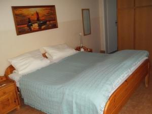 a bedroom with a large bed with a blue blanket at Ankerplatz H-7 in Butjadingen