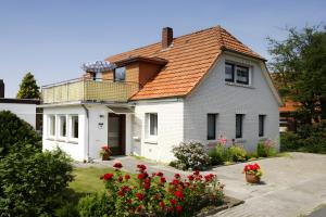 a white house with an orange roof at Ankerplatz H-7 in Butjadingen