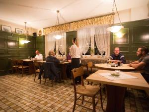 een groep mensen die aan tafel zitten in een restaurant bij Hotel Zur Stemmer Post in Minden