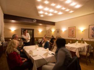 een groep mensen die aan tafel zitten in een restaurant bij Hotel Zur Stemmer Post in Minden