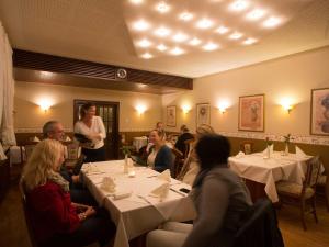 a group of people sitting at tables in a restaurant at Hotel Zur Stemmer Post in Minden
