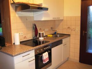 a small kitchen with a stove and a sink at Kajüte H-8 in Butjadingen