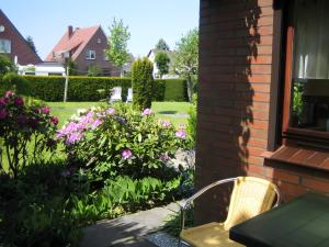 a garden with flowers and a chair next to a house at Kajüte H-8 in Butjadingen +2 photos