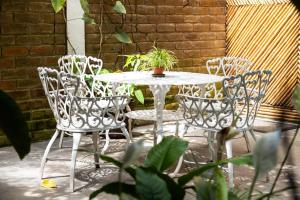 a white table and chairs with a potted plant on it at Arbol de Fuego Eco-hotel in San Salvador +49 photos