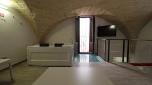 a room with a tub and a television in a room at Mastropaolo42 Luxury B&B in Grottaglie